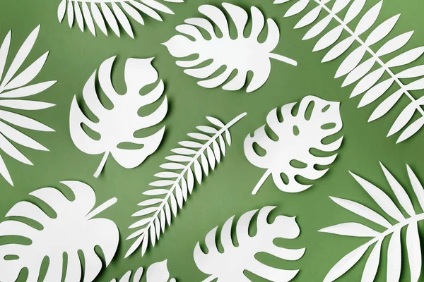 Tropical leaves pattern. Various paper leaves on green background. Paper art. Flat lay, top view