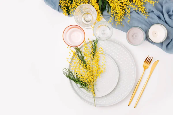 お祝いテーブル設定 皿やカトラリー灰色装飾的な織物と白い背景の上の黄色の花 美しいアレンジメント — ストック写真