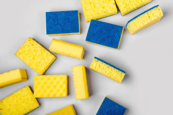 Губки на сером фоне. Предыстория уборки или ведения домашнего хозяйства. Принято. Плоский, вид сверху
.