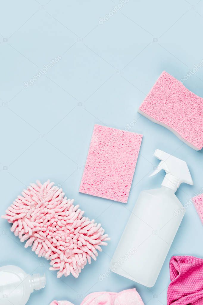 Detergents and cleaning accessories  in pink color.  Cleaning service concept. Flat lay, Top view.