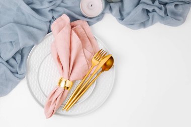 Festival tablo ayarı. Tabak ve çatal bıçak takımı gri Dekoratif Tekstil ve beyaz arka plan üzerinde pembe peçete ile. Güzel düz yatıyordu düzenleme.