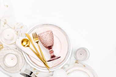 Sofra ve süslemeleri şenlikli bir tablo hizmet için. Tabaklar, şarap, gözlük ve çatal bıçak takımı ile beyaz zemin üzerine Dekoratif Tekstil