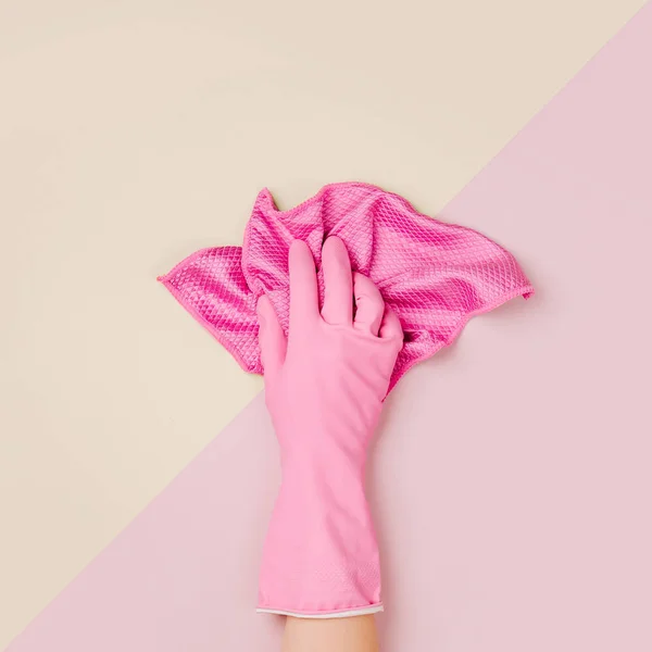 Female hand cleaning on pale pink  background. Cleaning or housekeeping concept background. Copy space.  Flat lay, Top view.