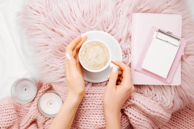 Fincan kakao kabarık kürk ekose Pano ve mum üzerinde tutan eller