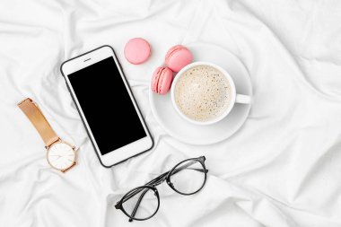 Fincan kahve ve yatakta smartphone.