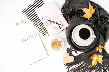 Eşarp, gözlük çalışma alanı boş oyun kağıdı, kahve fincanı ile defter ile sarılmış.