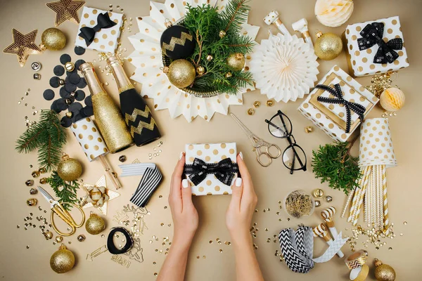 Mãos Femininas Segurando Caixa Presente Mesa Com Decorações Garrafas Champanhe — Fotografia de Stock