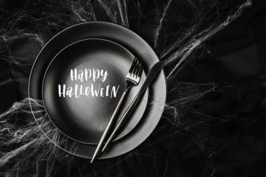 siyah çatal ve örümcek ağı, siyah plakalar görünümünü en iyi Cadılar Bayramı sofra mutlu helloween yazı ile koyu arka plan üzerinde