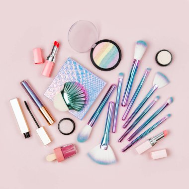 Sanal moda makyaj fırçaları göz farı, toz ve diğer kozmetik ürünleri pastel pembe bir arka plan üzerinde renkli. Düz yatıyordu, en iyi görünümü