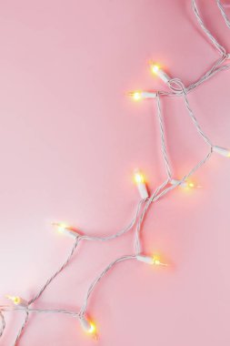 pembe bir arka plan üzerinde sıcak ışığıyla parlayan garland