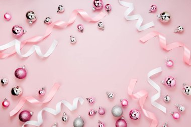 çerçeve Noel baubles ve pastel pembe arka plan şeritler