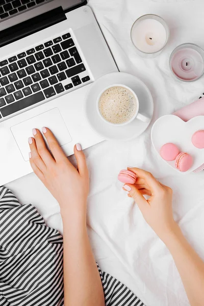 Kadın el laptop ile kahve fincanı ve macaroons, üstten görünüm