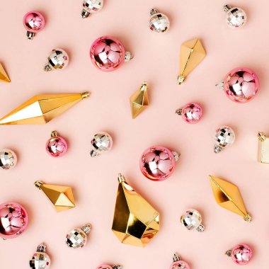 Parlak baubles ve pastel pembe bir arka plan üzerinde altın kristalleri ile şık Noel arka plan