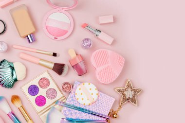 Kadın kozmetik kolaj ruj, fırça ve diğer aksesuarları üzerinde pembe bir arka plan ile. Düz yatıyordu, en iyi görünümü.
