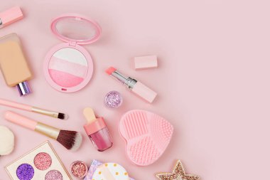 Kadın kozmetik kolaj ruj, fırça ve diğer aksesuarları üzerinde pembe bir arka plan ile. Düz yatıyordu, en iyi görünümü.