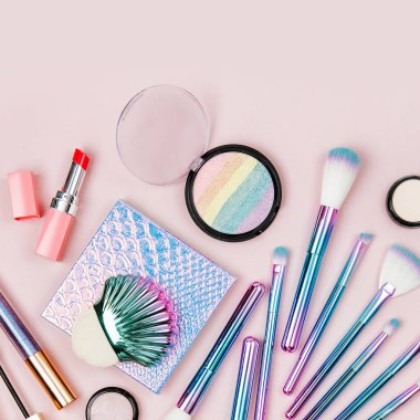 Sanal moda makyaj fırçaları göz farı, toz ve diğer kozmetik ürünleri pastel pembe bir arka plan üzerinde renkli. Düz yatıyordu, en iyi görünümü