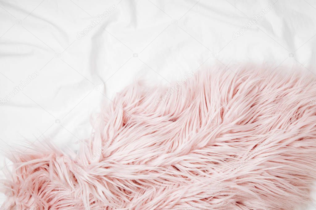 top view of pink fluffy fur plaid on bed