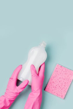 sünger ve pembe lastik eldiven temizleyici şişe tutan ellere 