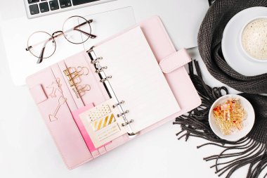 Çalışma alanı ile laptop, defter planlayıcısı, kahve Kupası ile eşarp, gözlük sarılmış. Şık ofis masası. Sonbahar ya da kış kavramı. Düz yatıyordu, en iyi görünümü