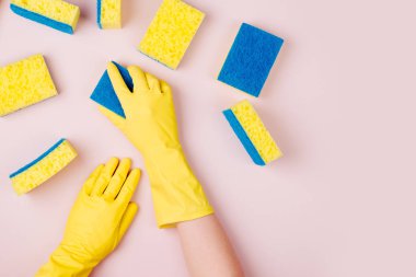 elinde lastik eldiven pembe arka plan üzerine sünger ile