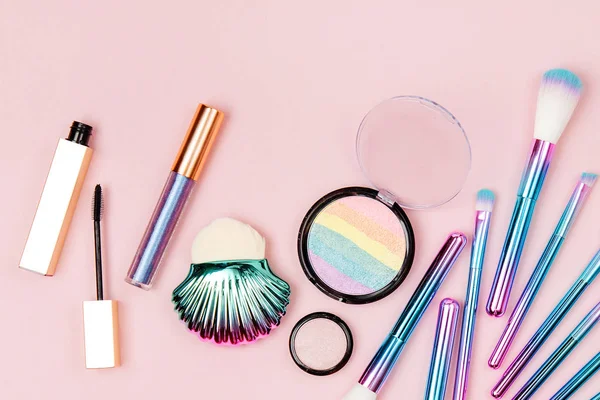 ファッション ホログラム色のアイシャドウとパステル ピンクの背景にパウダーで化粧筆 — ストック写真