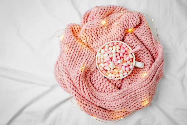 Cup of cacao with marshmallows on pink knitted plaid on bed — Stock Image Cup Cacao Marshmallows Pink Knitted Plaid Bed Stock Image