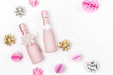 Soluk pembe Mini şişe şampanya konfeti ve beyaz arka plan üzerinde yay