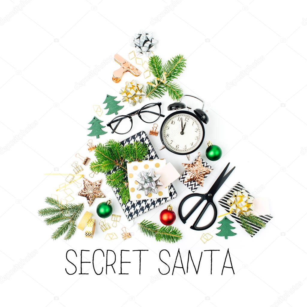 Christmas tree made from winter decorations, stationery with alarm clock and gifts on white background. Holiday and celebration creative concept. Flat lay, top view