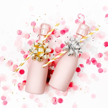 Soluk pembe Mini şişe şampanya ile beyaz zemin üzerine konfeti