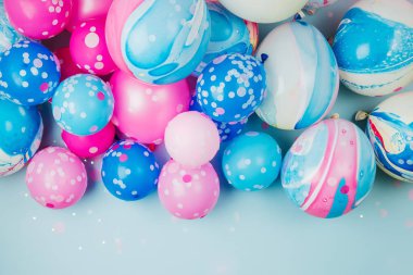 Pastel mavi arka plan üzerinde renkli balonlar