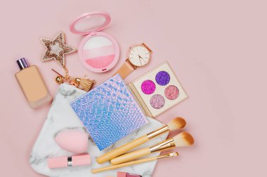 ruj, fırçalar ve diğer aksesuarları üzerinde pembe bir arka plan ile kozmetik kolaj
