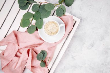 Beyaz ahşap servis tepsi ile çalar saat ve okaliptüs dalı kahve