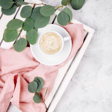 Beyaz ahşap servis tepsi ile çalar saat ve okaliptüs dalı kahve