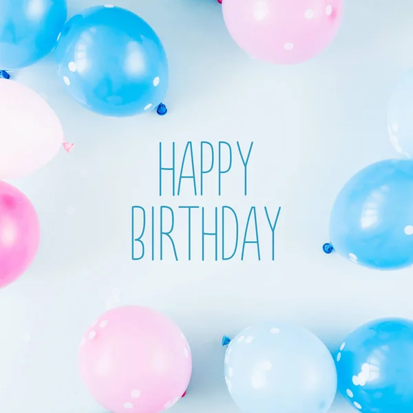 festive background with colorful balloons on pastel blue background with happy birthday lettering