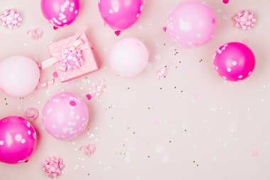 Pembe balonlar, hediye kutusu ve süslemeleri üzerinde pastel arka plan