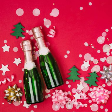 Konfeti ve tinsel kırmızı zemin üzerine şampanya şişeleri