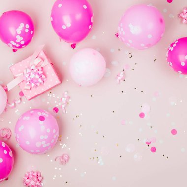 Pembe balonlar, hediye kutusu ve süslemeleri üzerinde pastel arka plan