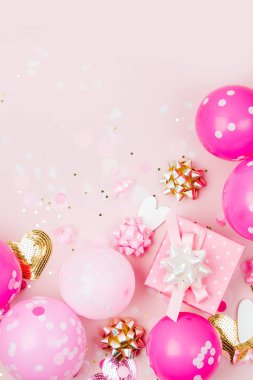 Pembe balonlar, hediye kutusu ve süslemeleri üzerinde pastel arka plan