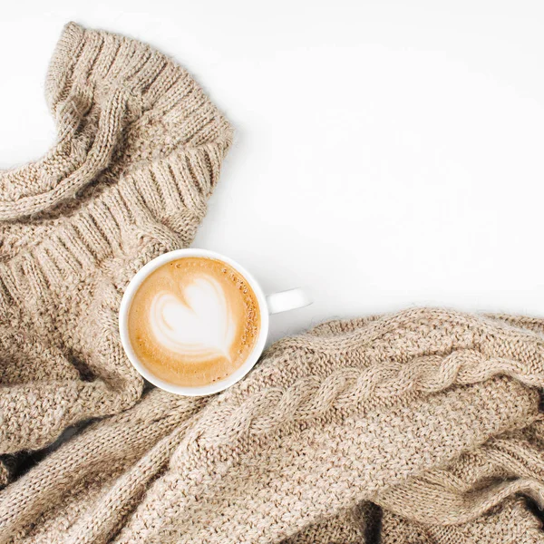 cup of coffee with knitted plaid on white background