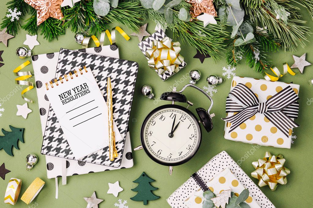 Christmas winter decorations, notebooks with alarm clock on green background
