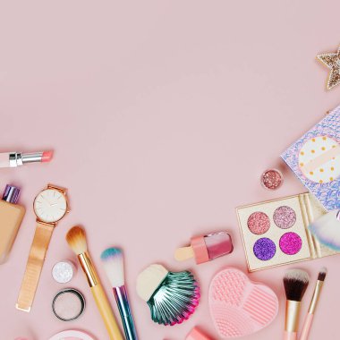Kadın kozmetik kolaj ruj, fırça ve diğer aksesuarları üzerinde pembe bir arka plan ile. Düz yatıyordu, en iyi görünümü.