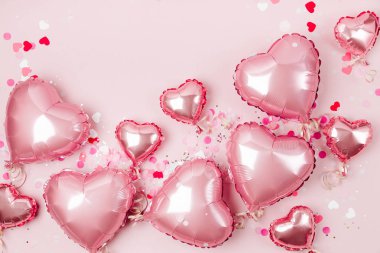 Hava balonları, kalp folyo pastel pembe bir arka plan üzerinde şeklinde. Aşk kavramı. Tatil kutlaması. Sevgililer günü veya düğün/bachelorette parti dekorasyon. Metalik balon