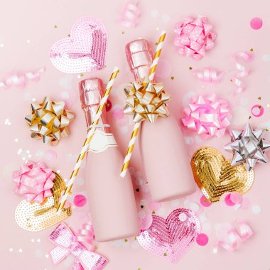 Mini şişe şampanya konfeti ve tinsel soluk pembe bir arka plan üzerinde. Sevgililer günü veya Doğum günü partisi konsepti tema. Düz yatıyordu, en iyi görünümü