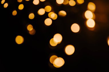 Siyah zemin üzerine altın bokeh ışıltı soyut. Işıklar bulanık bokeh Noel tasarımı için