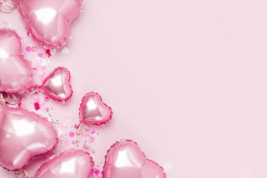 Hava balonları, kalp folyo pastel pembe bir arka plan üzerinde şeklinde. Aşk kavramı. Tatil kutlaması. Sevgililer günü veya düğün/bachelorette parti dekorasyon. Metalik balon