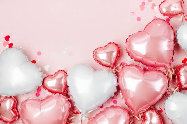Hava balonları, kalp folyo pastel pembe bir arka plan üzerinde şeklinde. Aşk kavramı. Tatil kutlaması. Sevgililer günü veya düğün/bachelorette parti dekorasyon. Metalik balon