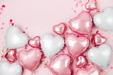 Hava balonları, kalp folyo pastel pembe bir arka plan üzerinde şeklinde. Aşk kavramı. Tatil kutlaması. Sevgililer günü veya düğün/bachelorette parti dekorasyon. Metalik balon