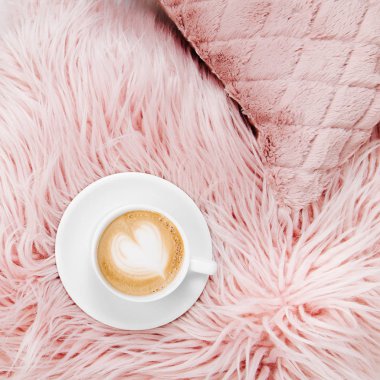 Sabah kavramı. Bir fincan kahve pembe bir yastık üzerine, terlik yatakta. Düz yatıyordu, en iyi görünümü