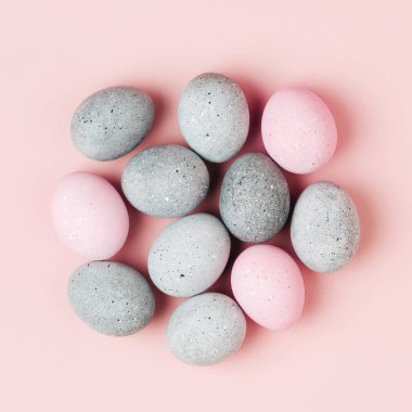 Pastel arka plan üzerinde soluk pembe ve gri Paskalya yumurtaları grup. Düz yatıyordu 