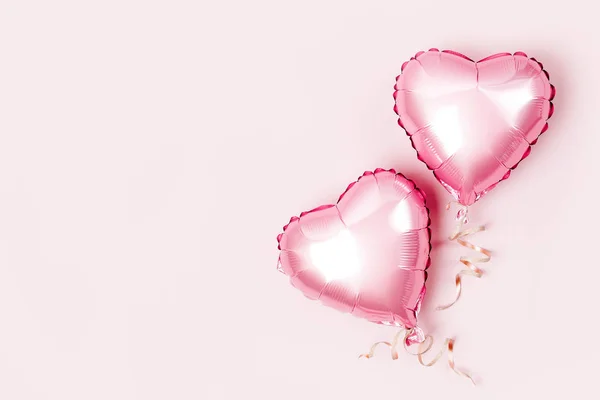 Hava balonları, kalp folyo pastel pembe bir arka plan üzerinde şeklinde. Aşk kavramı. Tatil kutlaması. Sevgililer günü veya düğün/bachelorette parti dekorasyon. Metalik balon